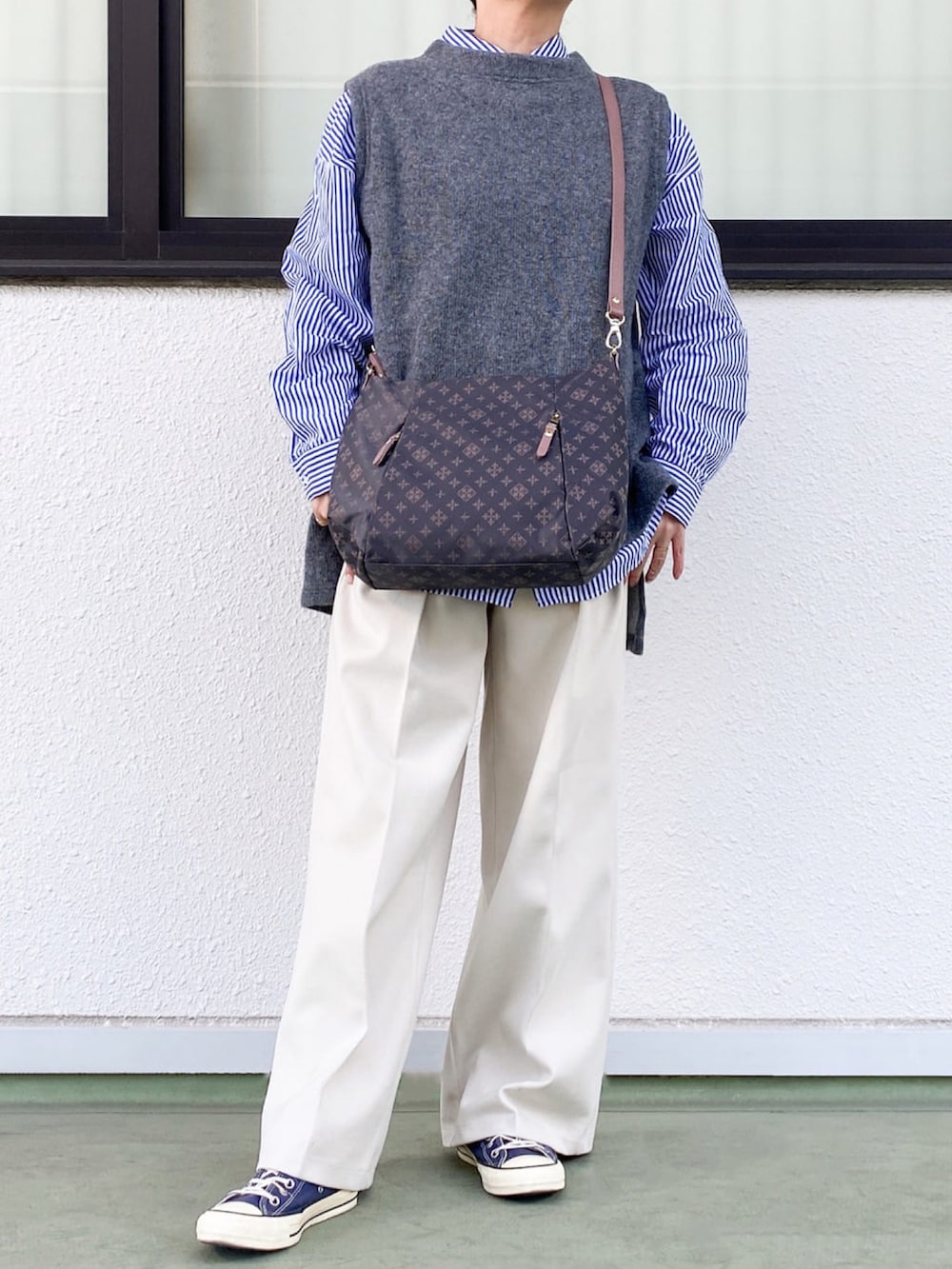 グレー系のショルダーバッグ、グレー系のベスト、ブルー系のシャツ/ブラウスを着用したレディースの冬コーディネートの3枚目の写真