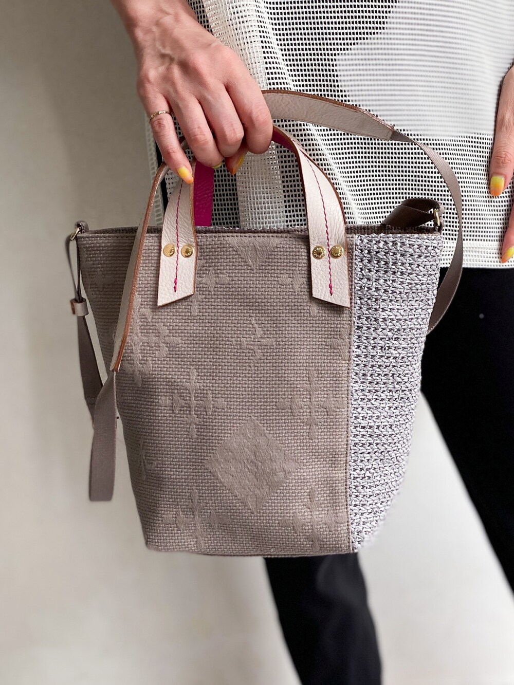 グレー系のショルダーバッグ、ホワイト系のTシャツ/カットソー、ブラック系のタンクトップを着用したレディースの春コーディネートの2枚目の写真