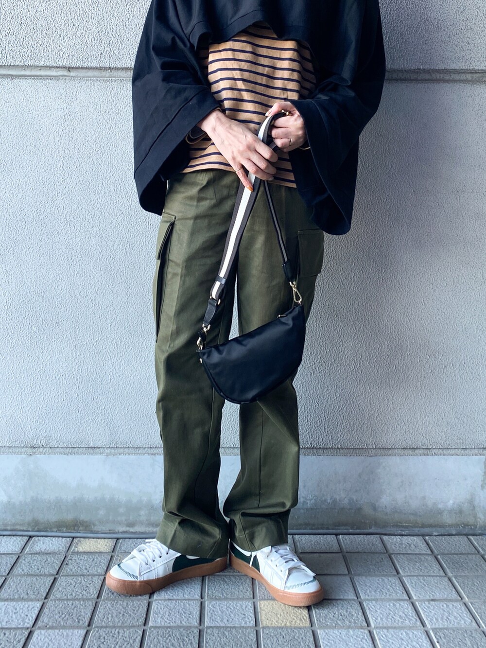 ブラック系のショルダーバッグ、ブラック系のTシャツ/カットソー、ベージュ系のTシャツ/カットソーを着用したレディースの冬コーディネートの3枚目の写真