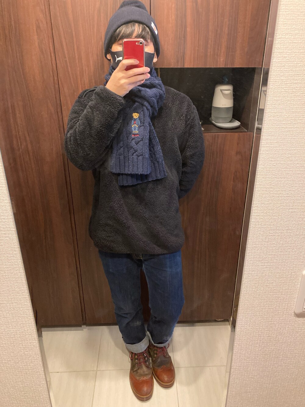 ブラウン系のブーツ、ブルー系のデニムパンツ、イエロー系のバッグを着用したメンズの冬コーディネートの2枚目の写真