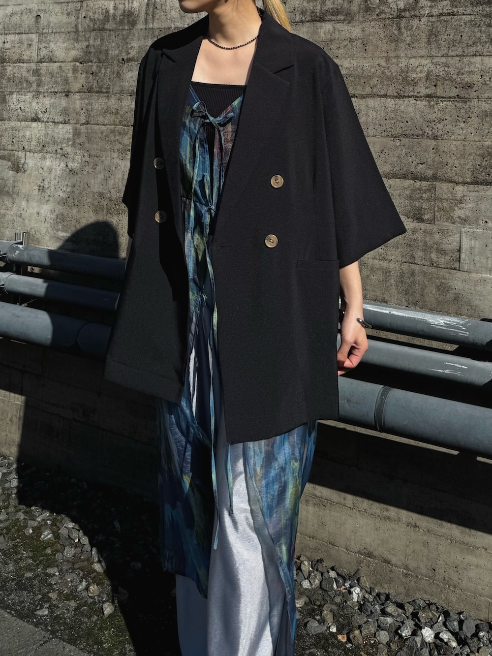 ブラック系のテーラードジャケット、シルバー系のその他パンツ、ブルー系のワンピースを着用したレディースの春コーディネートの2枚目の写真