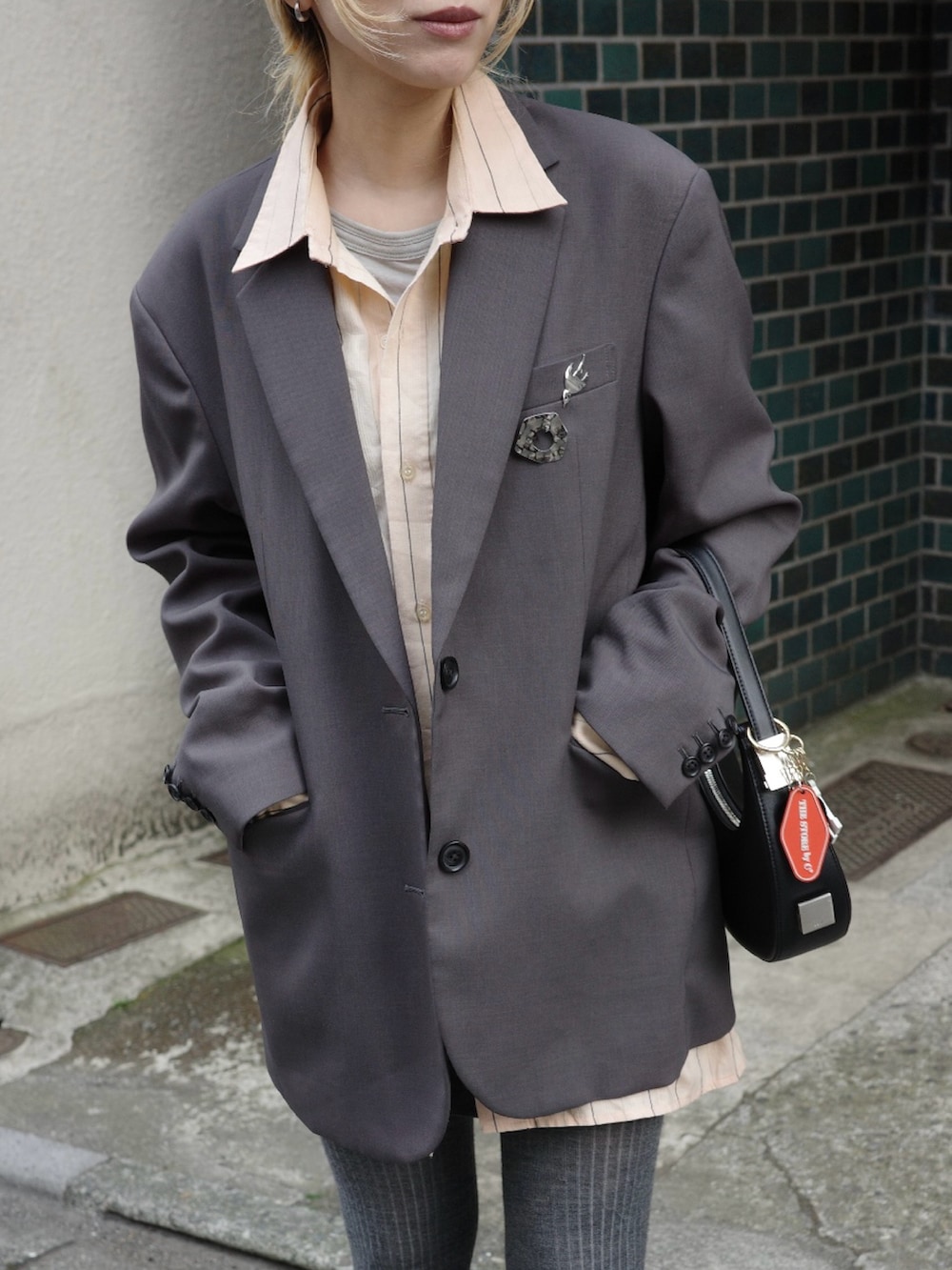 その他のローファー、ブラック系のハンドバッグ、グレー系のテーラードジャケットを着用したレディースの春コーディネートの4枚目の写真
