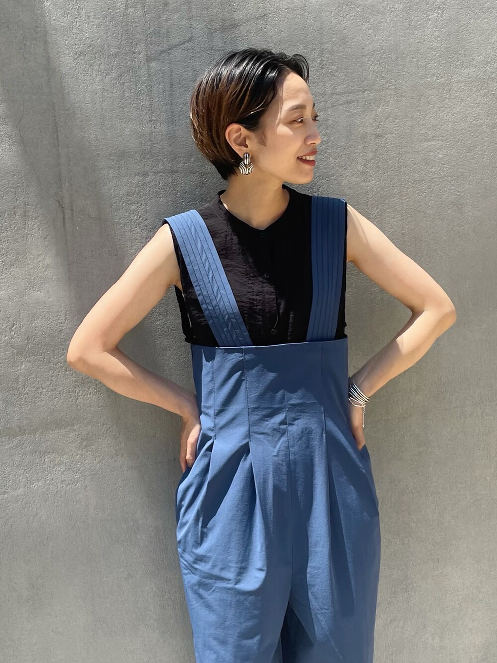 ブルー系のサロペット/オーバーオール、ブラック系のシャツ/ブラウスを着用したレディースの春コーディネートの2枚目の写真