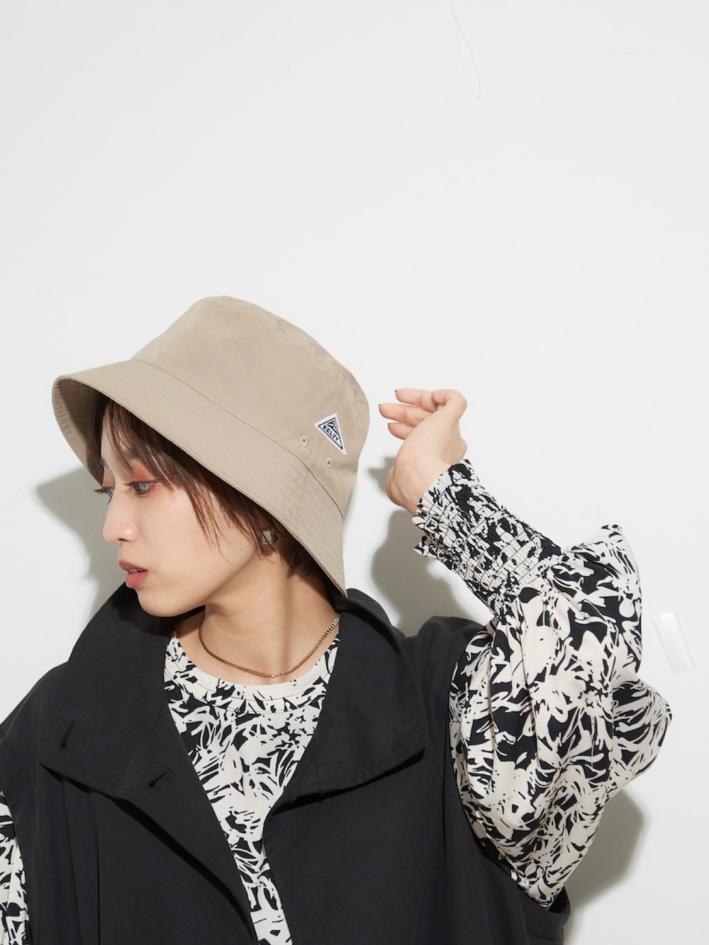 ホワイト系のサンダル、ホワイト系のワンピース、ブラック系のトレンチコートを着用したレディースの冬コーディネートの3枚目の写真