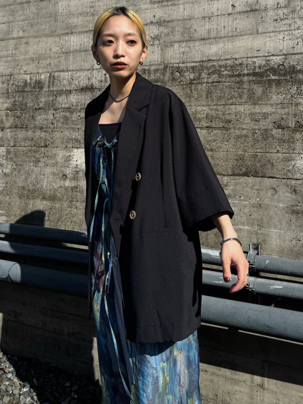 ブラック系のテーラードジャケット、シルバー系のその他パンツ、ブルー系のワンピースを着用したレディースの春コーディネートの4枚目の写真