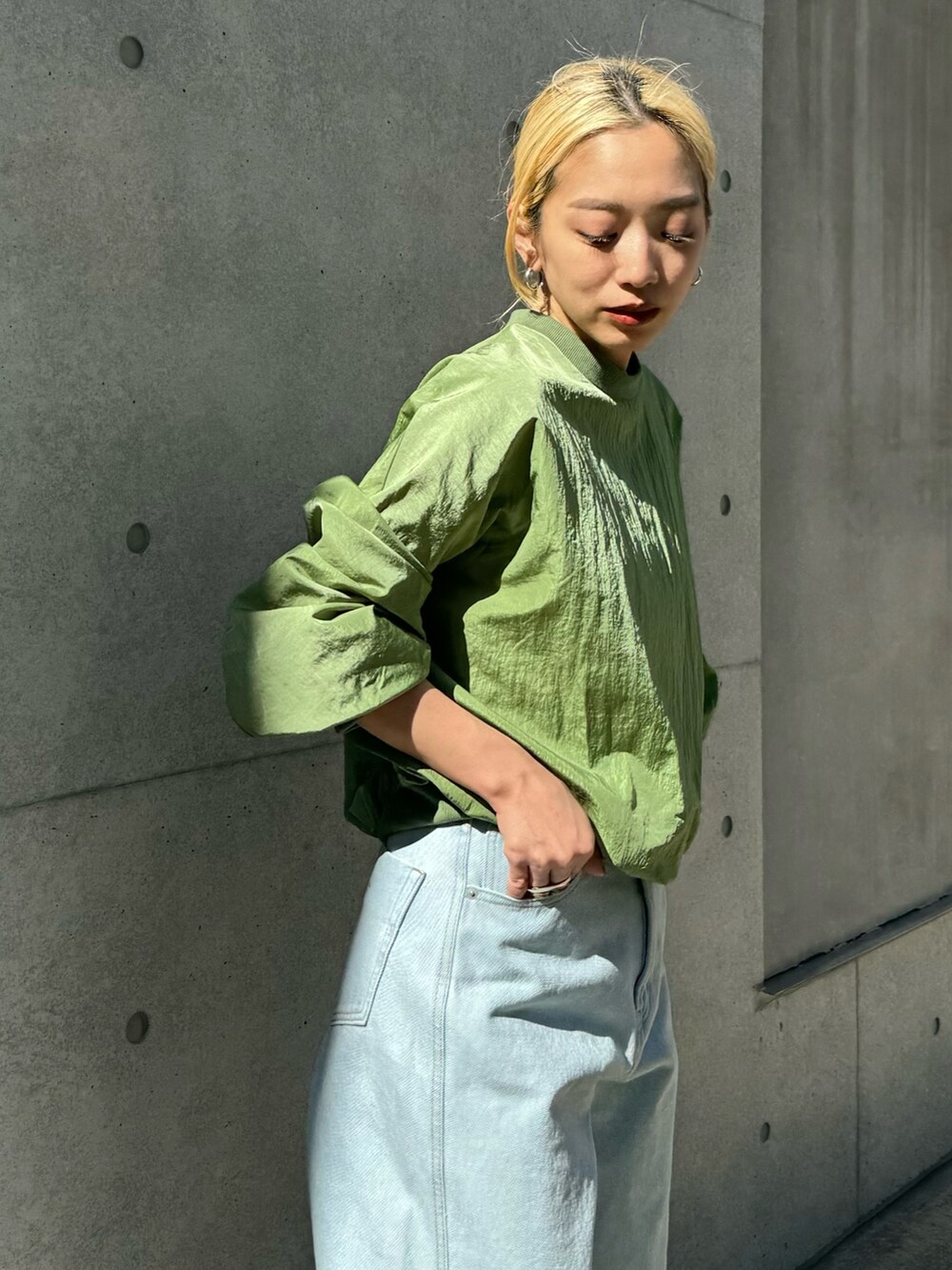 ホワイト系のスニーカー、ブルー系のデニムパンツ、グリーン系のシャツ/ブラウスを着用したレディースの春コーディネートの2枚目の写真