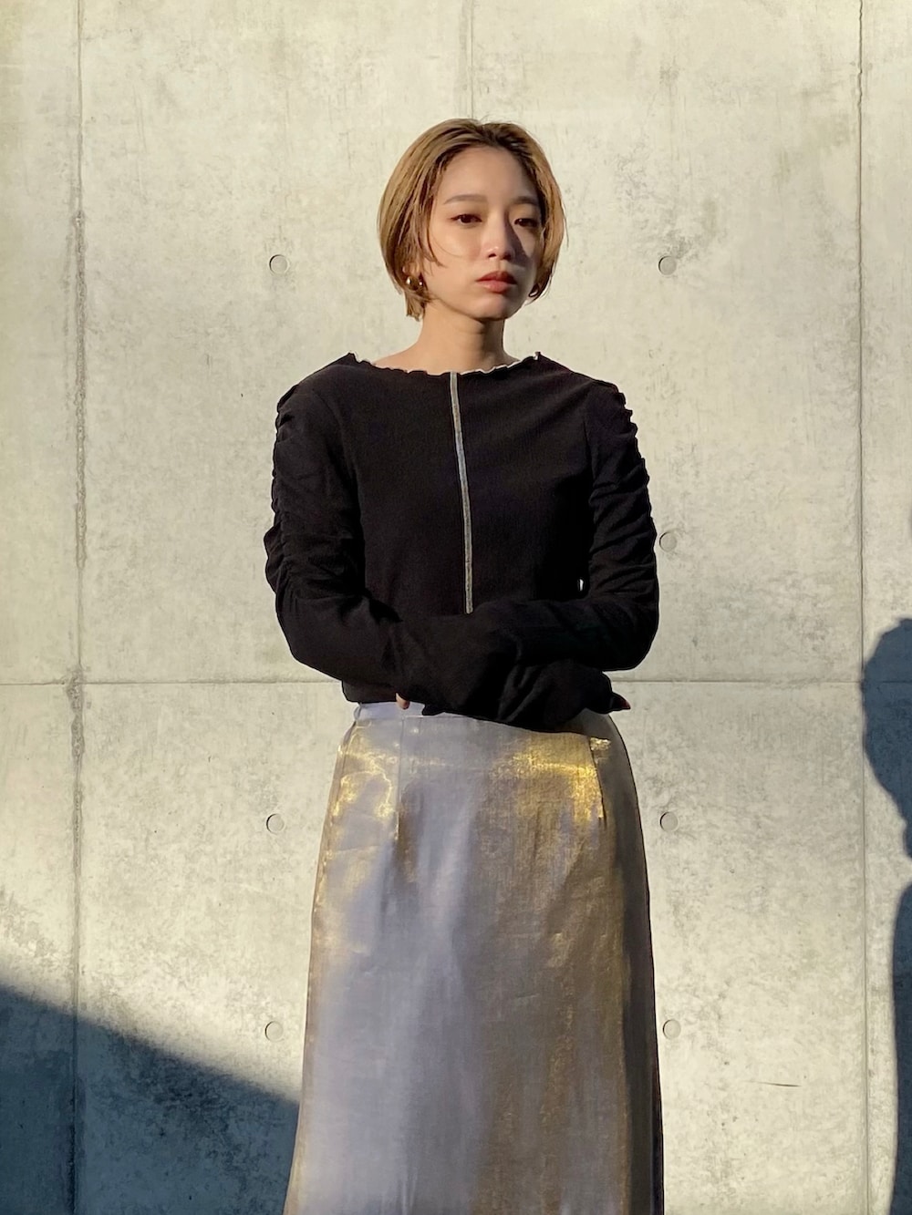 ブラック系のTシャツ/カットソー、グレー系のスカートを着用したレディースの冬コーディネートの2枚目の写真