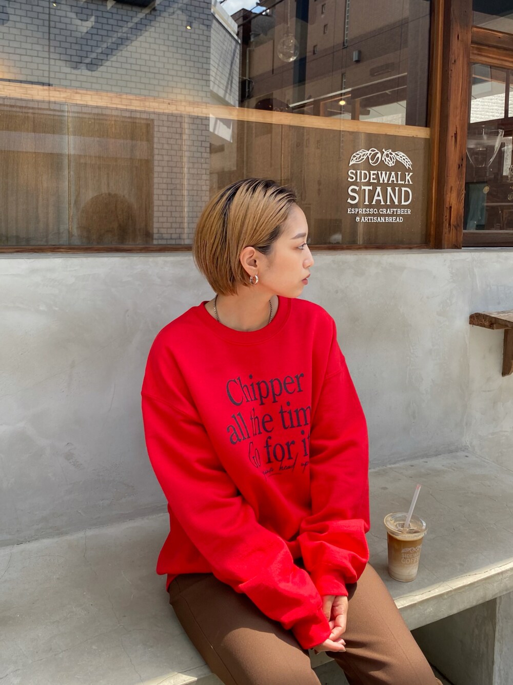 ブラウン系のスラックス、レッド系のスウェットを着用したレディースの冬コーディネートの2枚目の写真