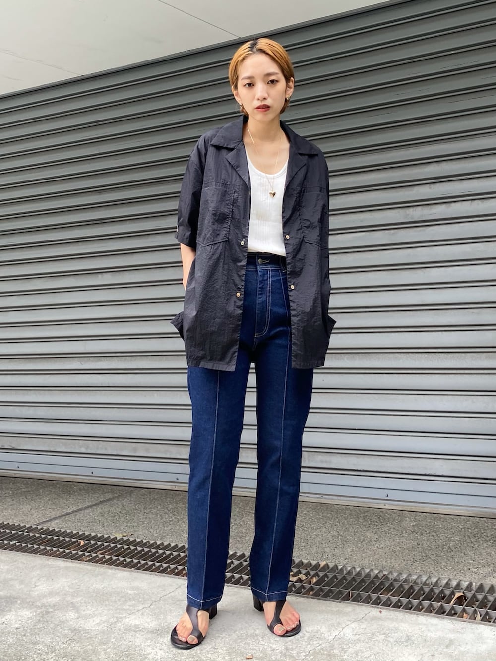 ブルー系のデニムパンツ、ブラック系のシャツ/ブラウス、ゴールド系のネックレスを着用したレディースの夏コーディネートの2枚目の写真