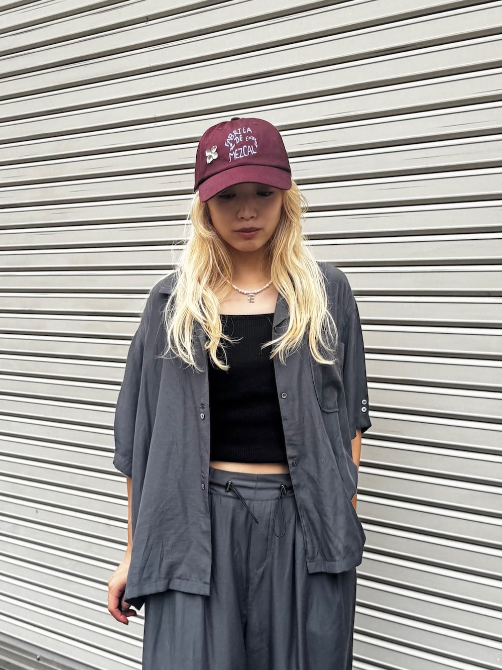 グレー系のシャツ/ブラウス、グレー系のその他パンツ、ブラック系のスニーカーを着用したレディースの夏コーディネートの3枚目の写真