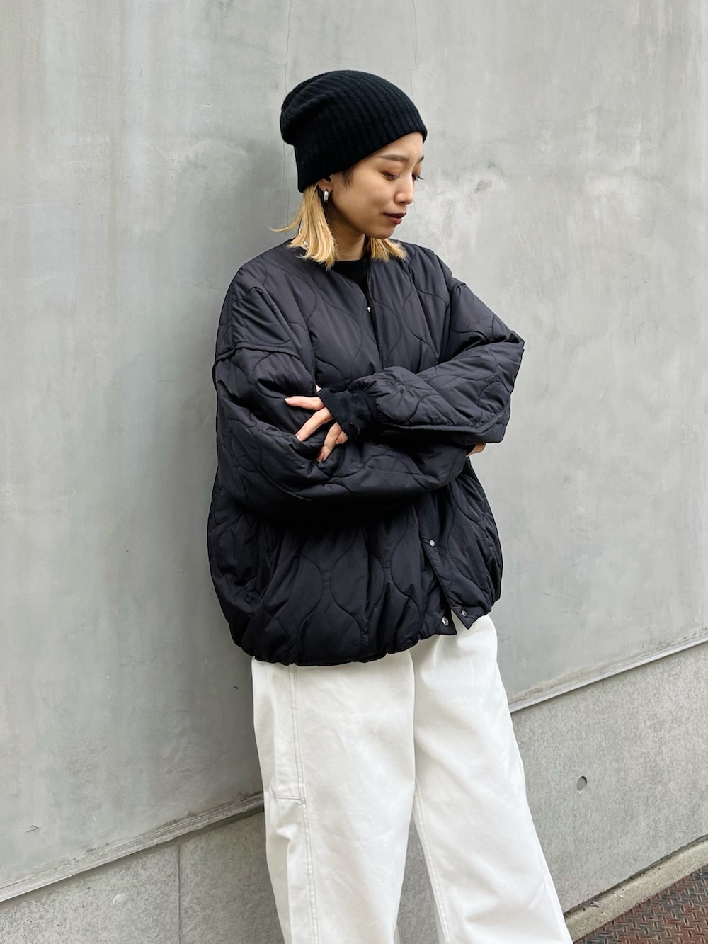 ホワイト系のデニムパンツ、ブラック系のスニーカー、ブラック系のブルゾンを着用したレディースの冬コーディネートの3枚目の写真