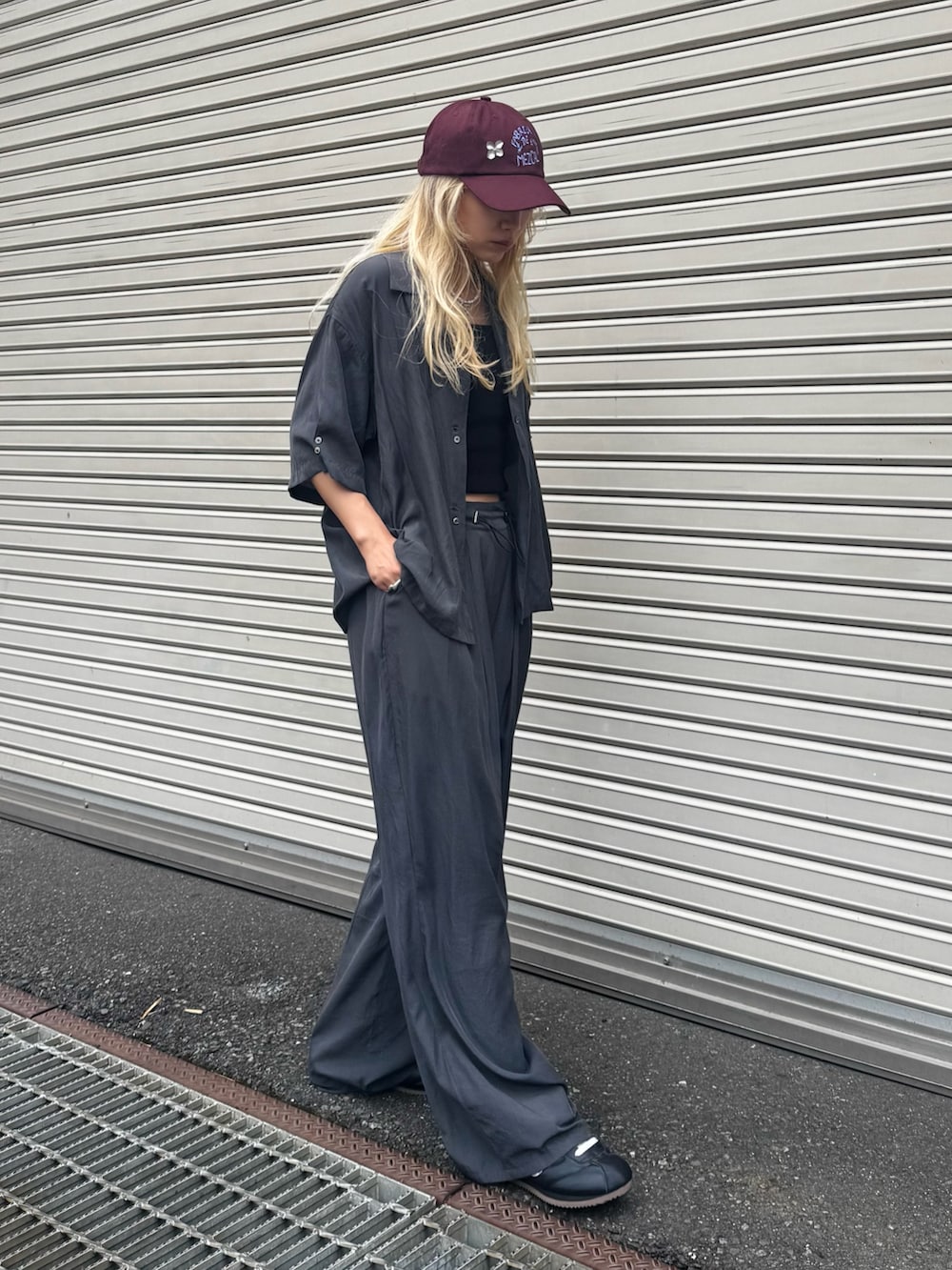 グレー系のシャツ/ブラウス、グレー系のその他パンツ、ブラック系のスニーカーを着用したレディースの夏コーディネートの2枚目の写真