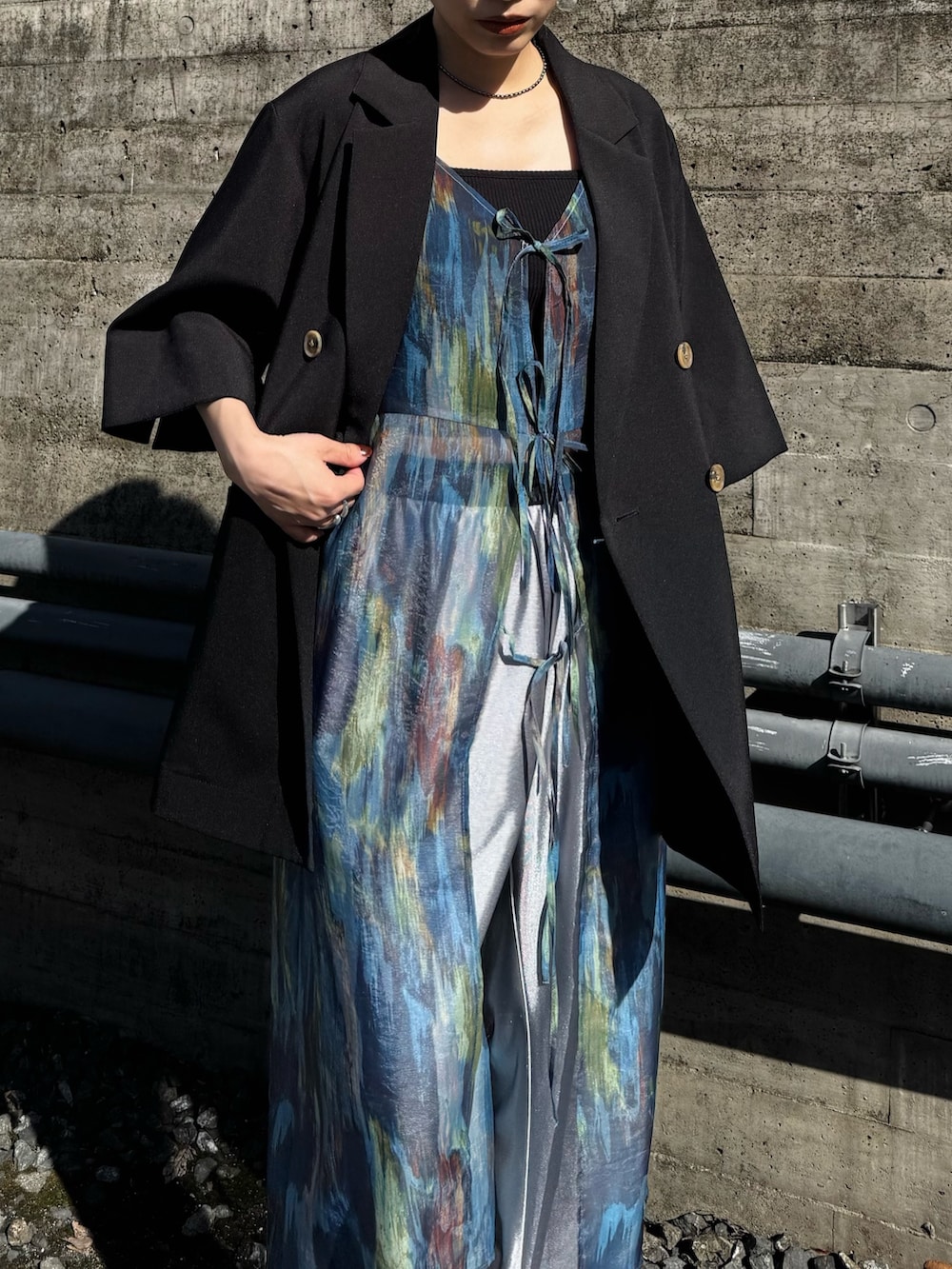 ブラック系のテーラードジャケット、シルバー系のその他パンツ、ブルー系のワンピースを着用したレディースの春コーディネートの3枚目の写真