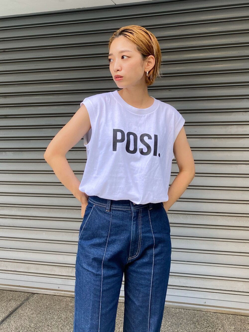 ホワイト系のタンクトップ、ブルー系のデニムパンツを着用したレディースの夏コーディネートの2枚目の写真