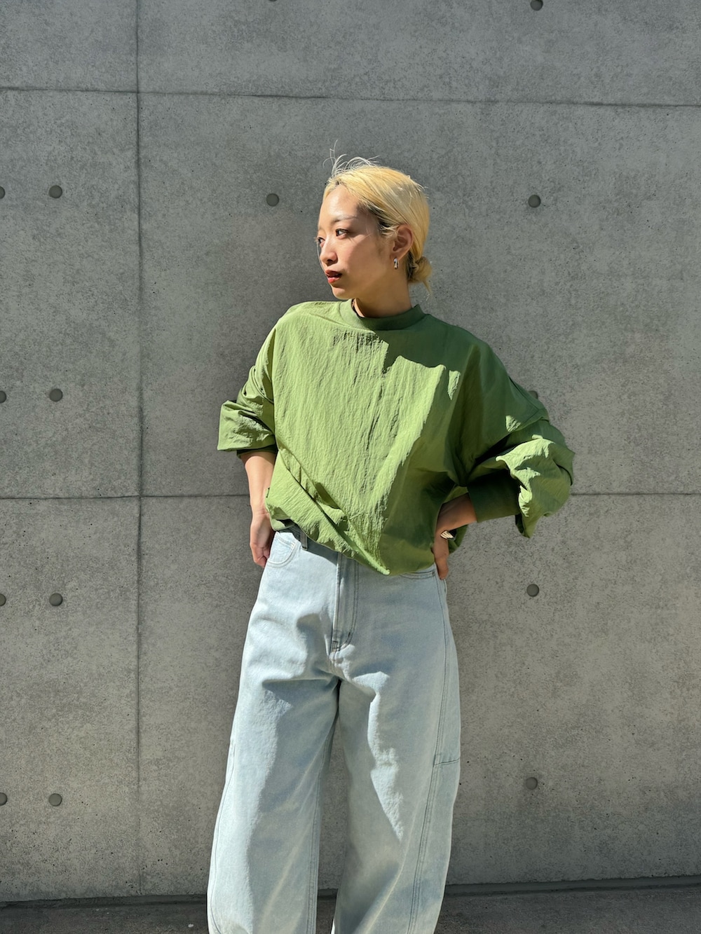 ホワイト系のスニーカー、ブルー系のデニムパンツ、グリーン系のシャツ/ブラウスを着用したレディースの春コーディネートの3枚目の写真