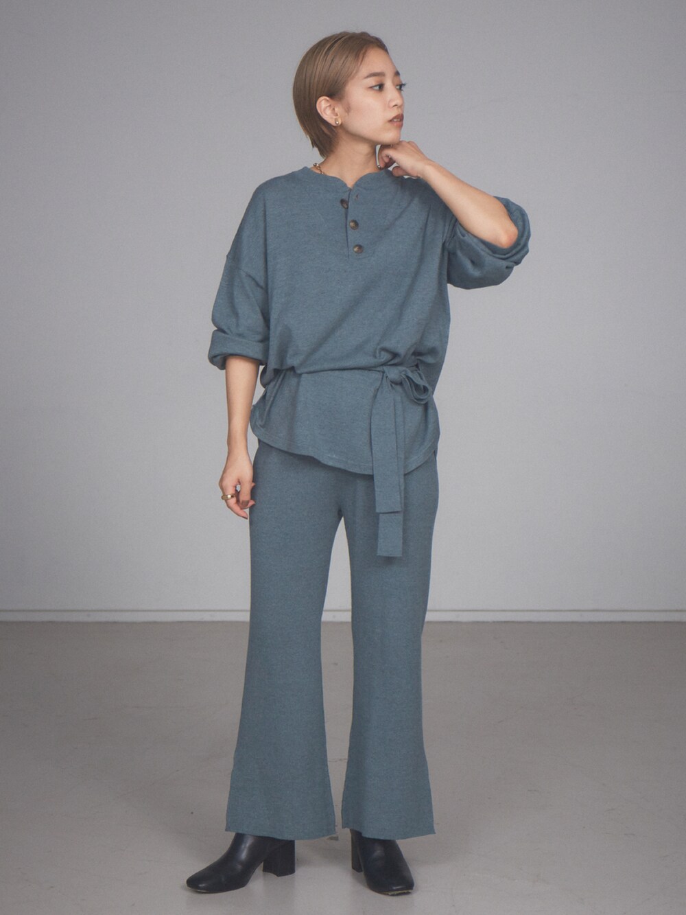 グリーン系のニット/セーターを着用したレディースの秋コーディネートの2枚目の写真