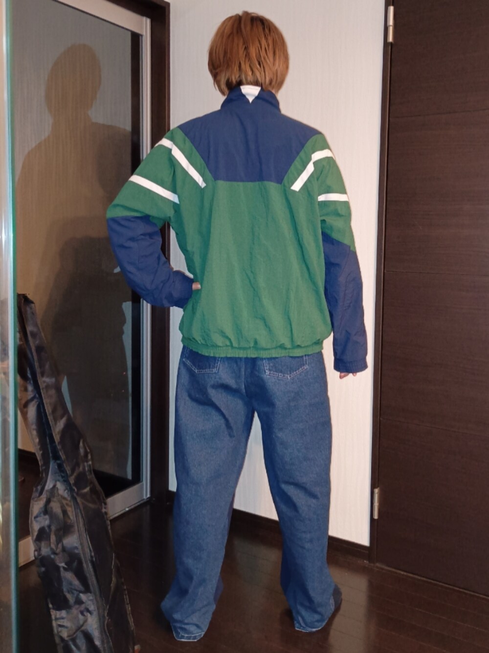 ブルー系のスウェットパンツ、グレー系のTシャツ/カットソー、グリーン系のナイロンジャケットを着用したメンズの秋コーディネートの5枚目の写真