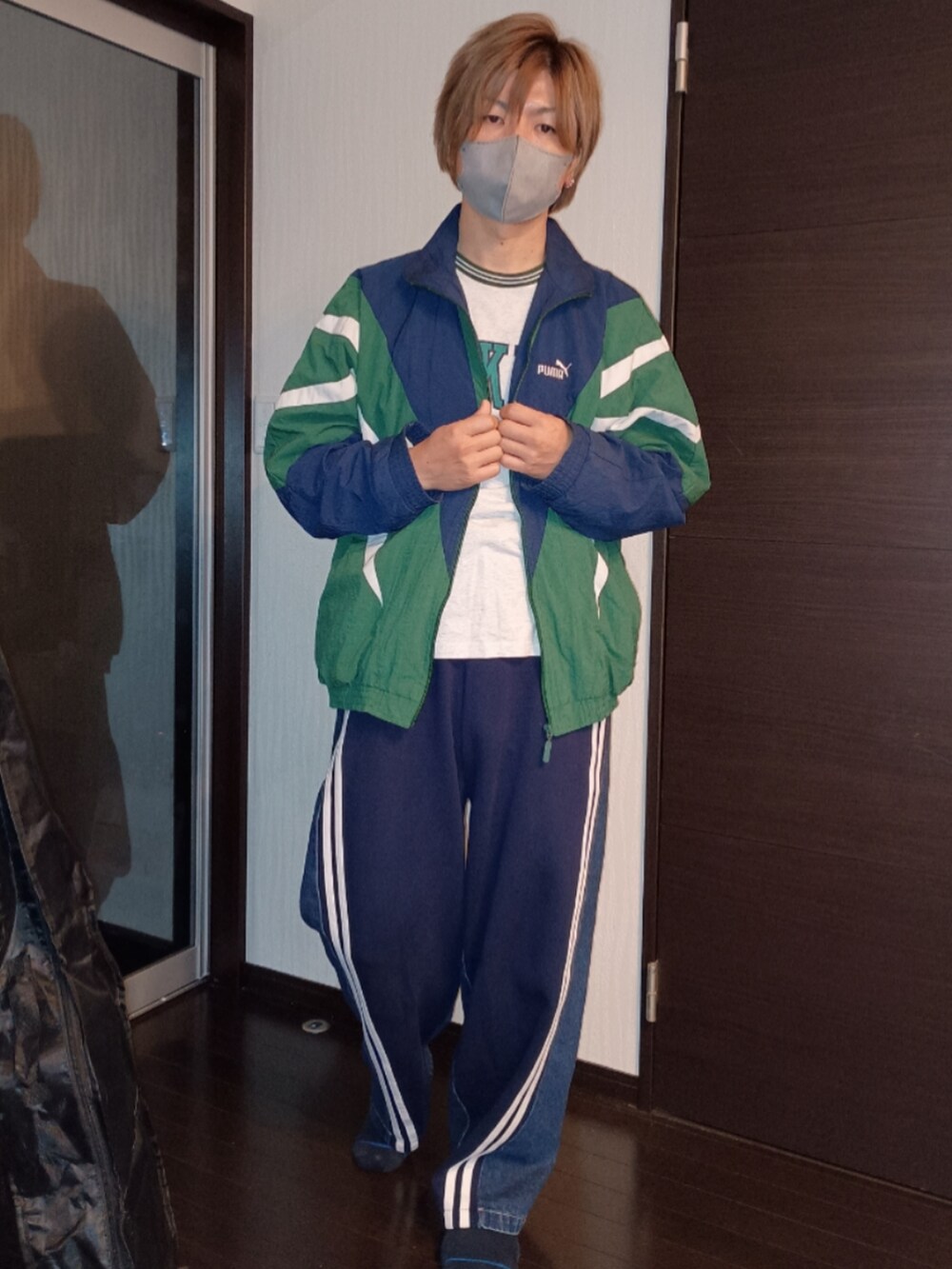 ブルー系のスウェットパンツ、グレー系のTシャツ/カットソー、グリーン系のナイロンジャケットを着用したメンズの秋コーディネートの3枚目の写真