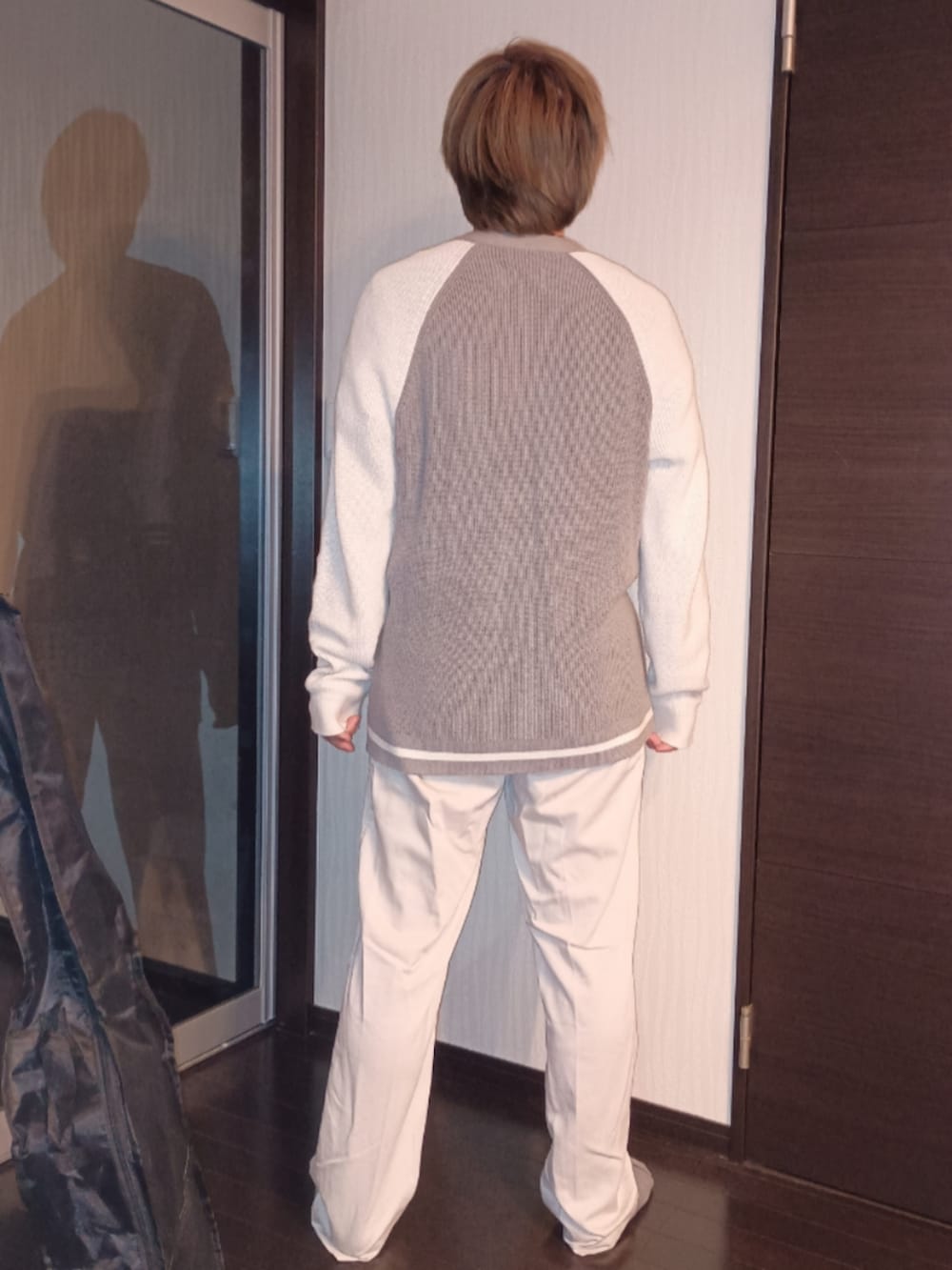 ホワイト系のデニムパンツ、グレー系のニット/セーター、ブラック系のTシャツ/カットソーを着用したメンズの秋コーディネートの5枚目の写真