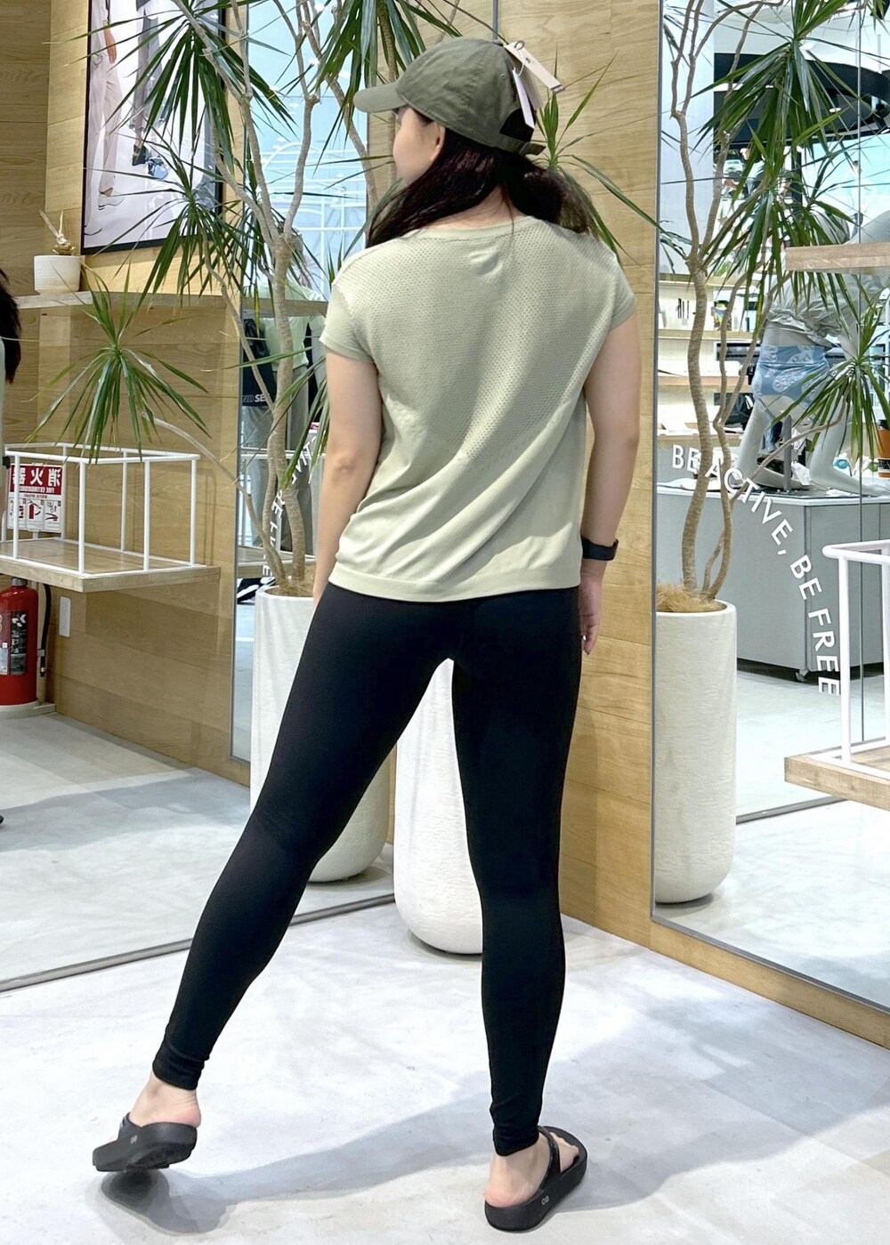 ブラック系のサンダル、グリーン系のTシャツ/カットソー、ブラック系のレギンス/スパッツを着用したレディースの夏コーディネートの3枚目の写真