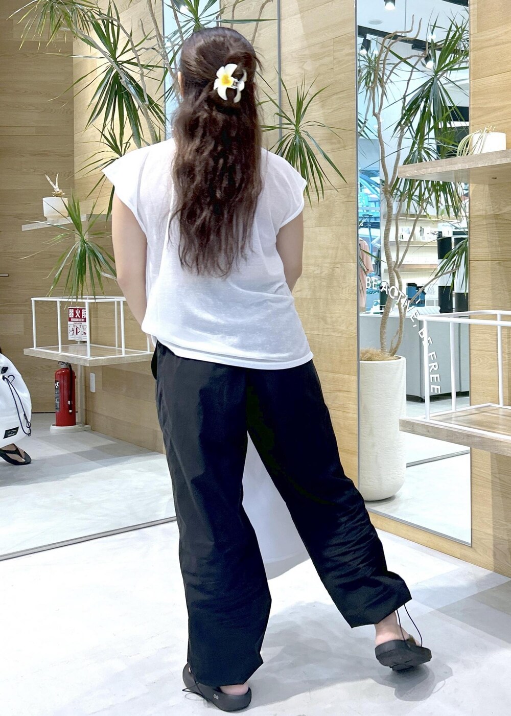 ブラック系のその他パンツ、ブラック系のサンダル、ホワイト系のバックパック/リュックを着用したレディースの秋コーディネートの4枚目の写真