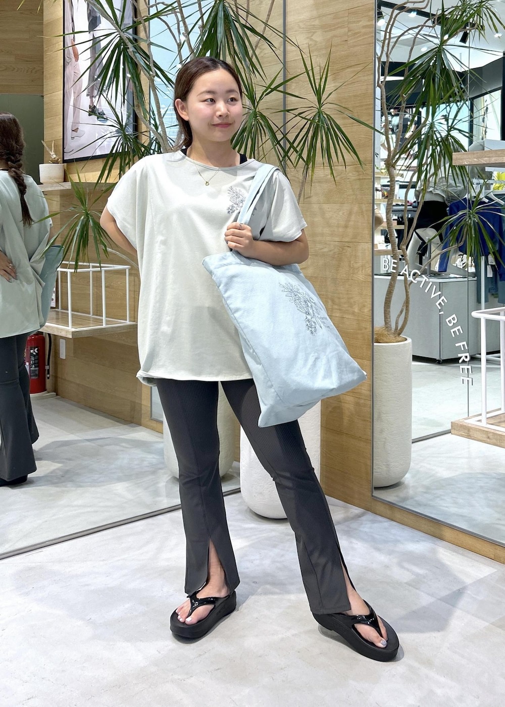 グレー系のカーゴパンツ、ブラック系のサンダル、グリーン系のTシャツ/カットソーを着用したレディースの夏コーディネートの2枚目の写真