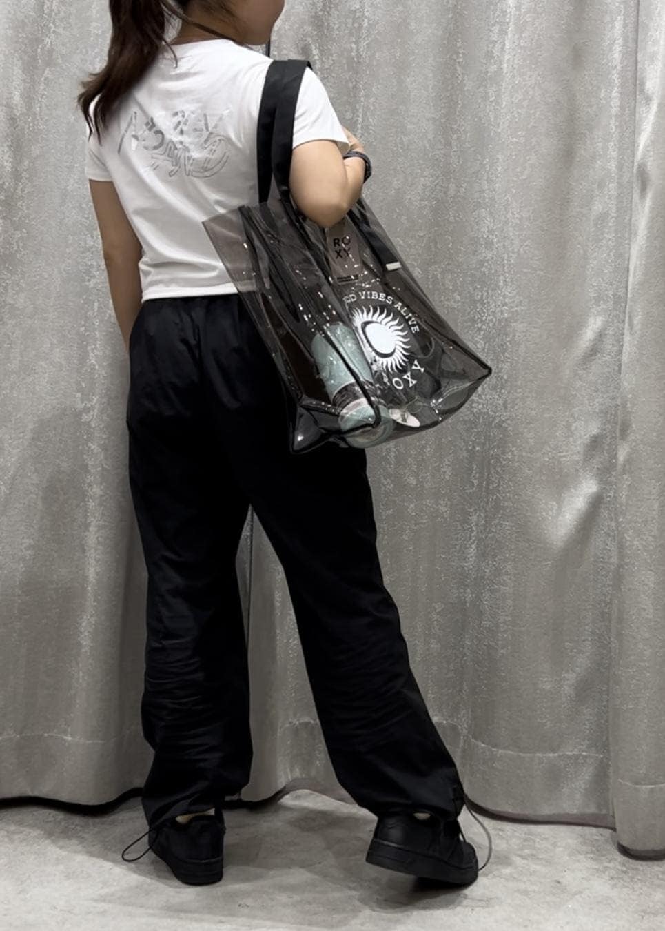 ブラック系のその他パンツ、ブラック系のスニーカー、ホワイト系のTシャツ/カットソーを着用したレディースの春コーディネートの3枚目の写真