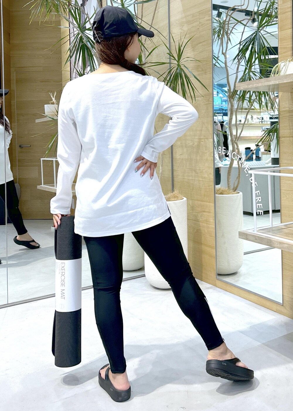 ブラック系のサンダル、ホワイト系のTシャツ/カットソー、グリーン系のスポーツグッズを着用したレディースの夏コーディネートの3枚目の写真