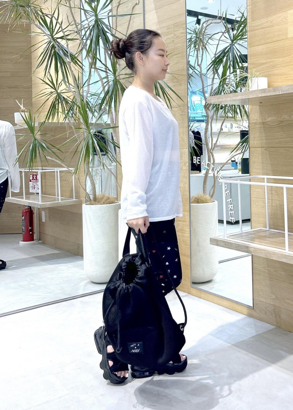 ブラック系のサンダル、ホワイト系のTシャツ/カットソー、ブラック系のスポーツブラを着用したレディースの夏コーディネートの2枚目の写真