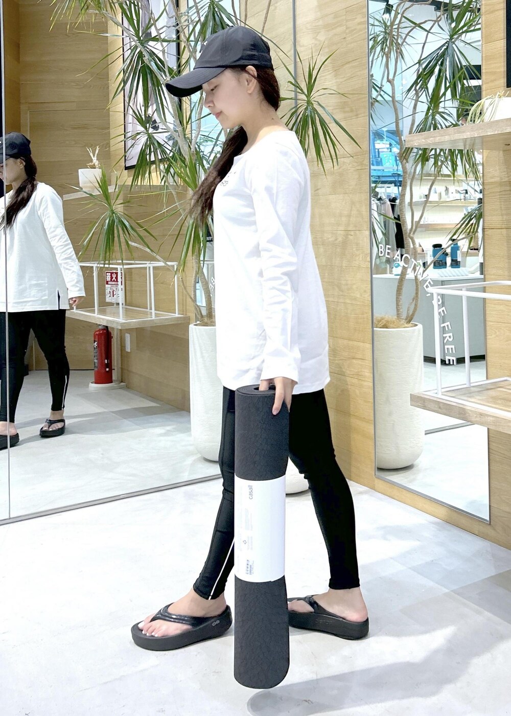 ブラック系のサンダル、ホワイト系のTシャツ/カットソー、グリーン系のスポーツグッズを着用したレディースの夏コーディネートの2枚目の写真