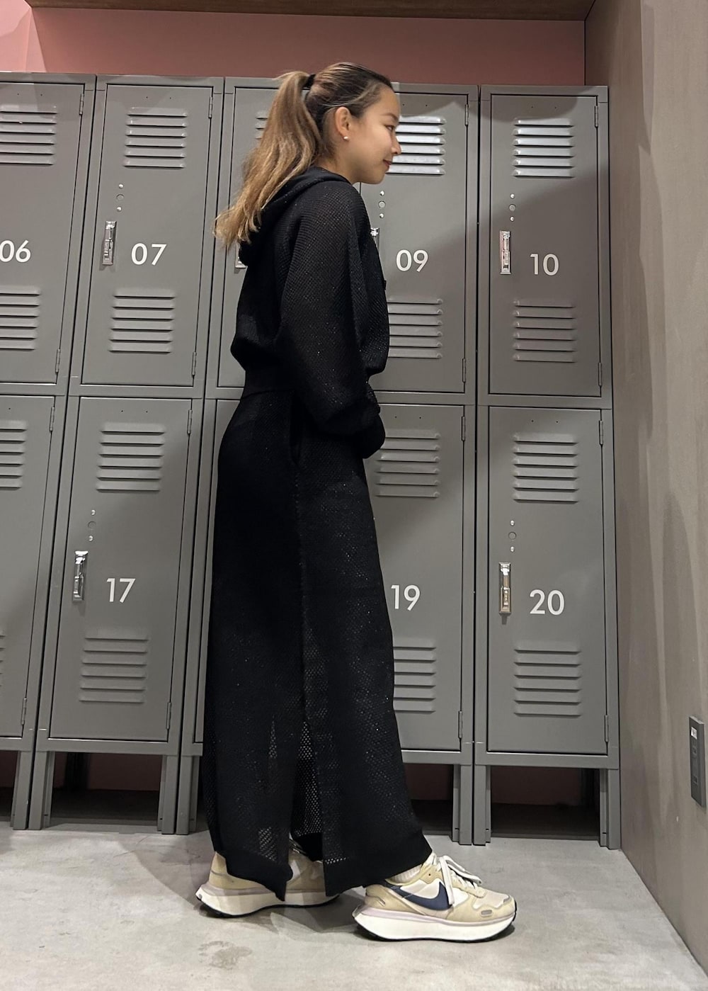 ベージュ系のスニーカー、ブラック系のパーカー、ブラック系のスカートを着用したレディースの冬コーディネートの4枚目の写真