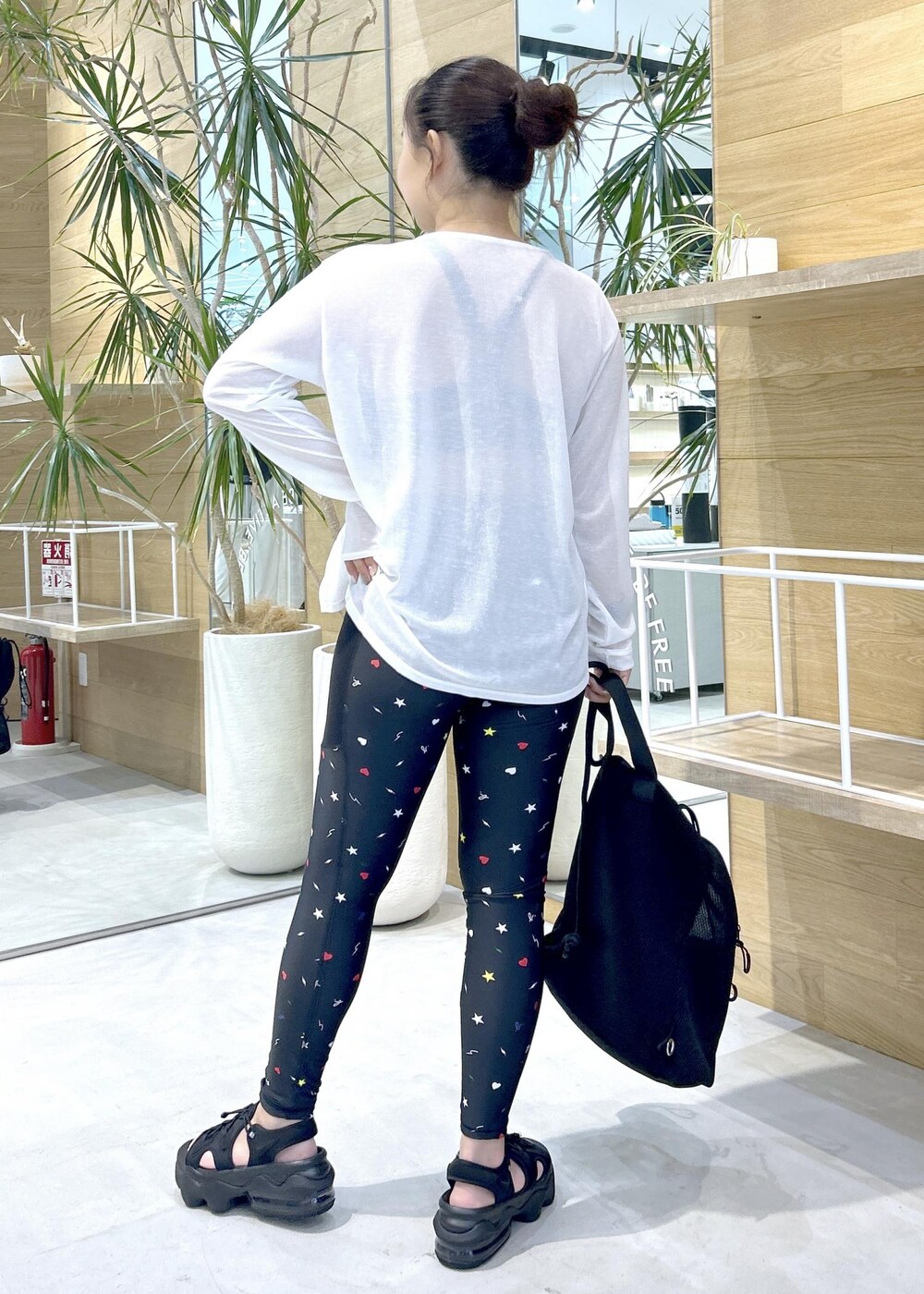 ブラック系のサンダル、ホワイト系のTシャツ/カットソー、ブラック系のスポーツブラを着用したレディースの夏コーディネートの3枚目の写真