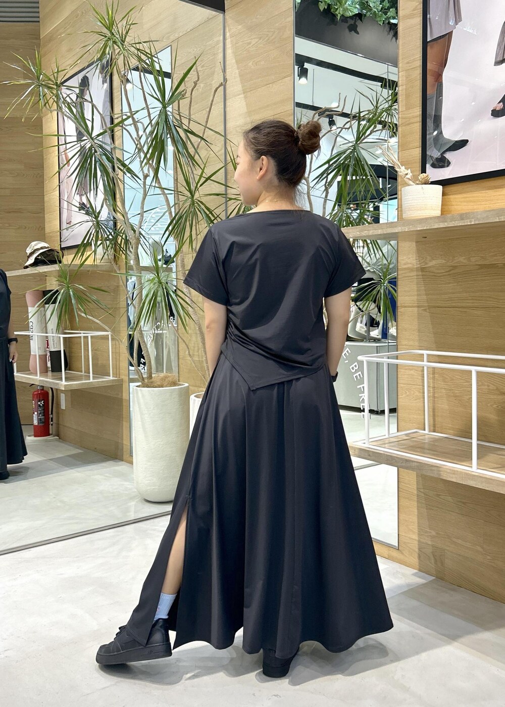 ブラック系のスニーカー、ブラック系のTシャツ/カットソー、ブラック系のスカートを着用したレディースの春コーディネートの3枚目の写真