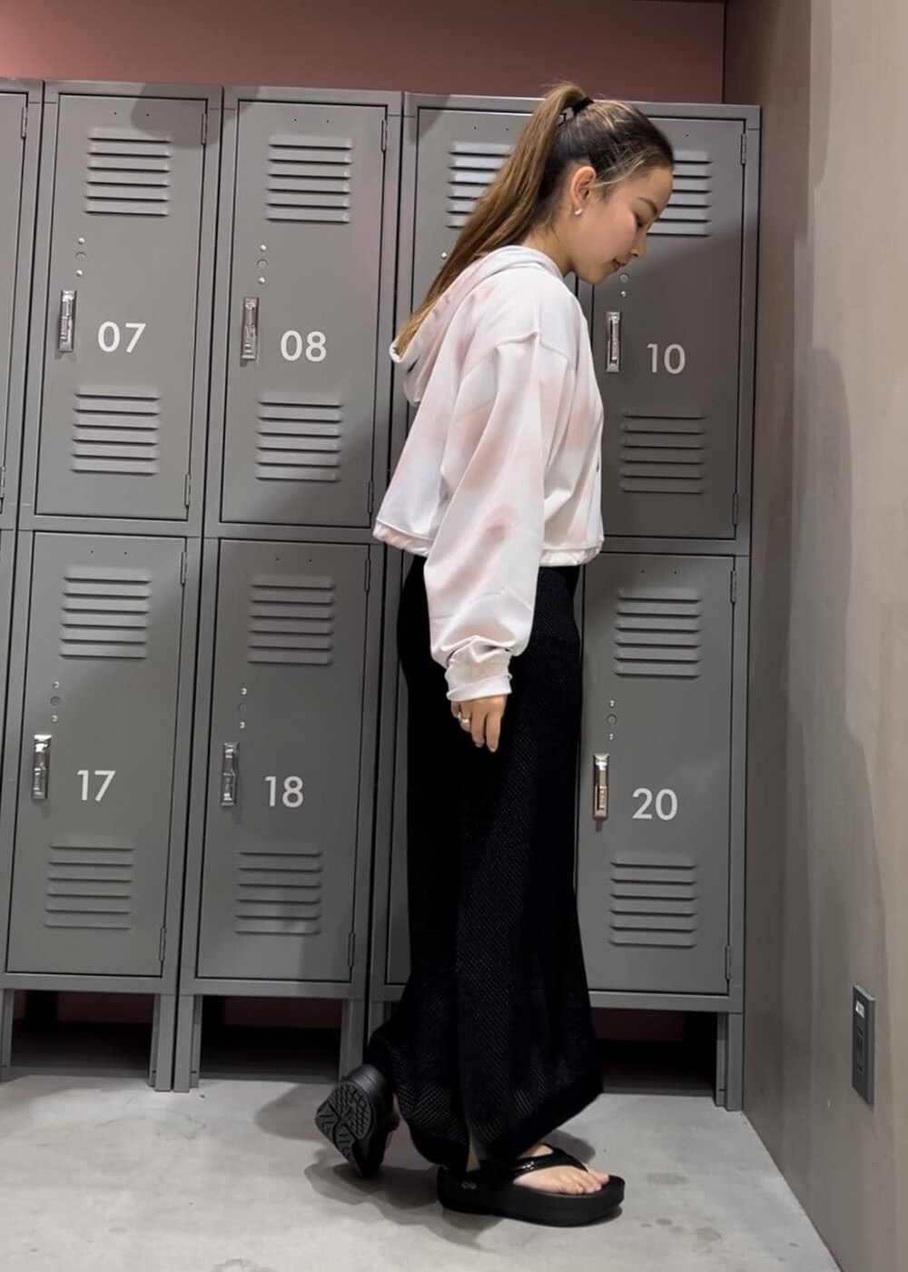 ブラック系のサンダル、ホワイト系のパーカー、ブラック系のスカートを着用したレディースの春コーディネートの4枚目の写真