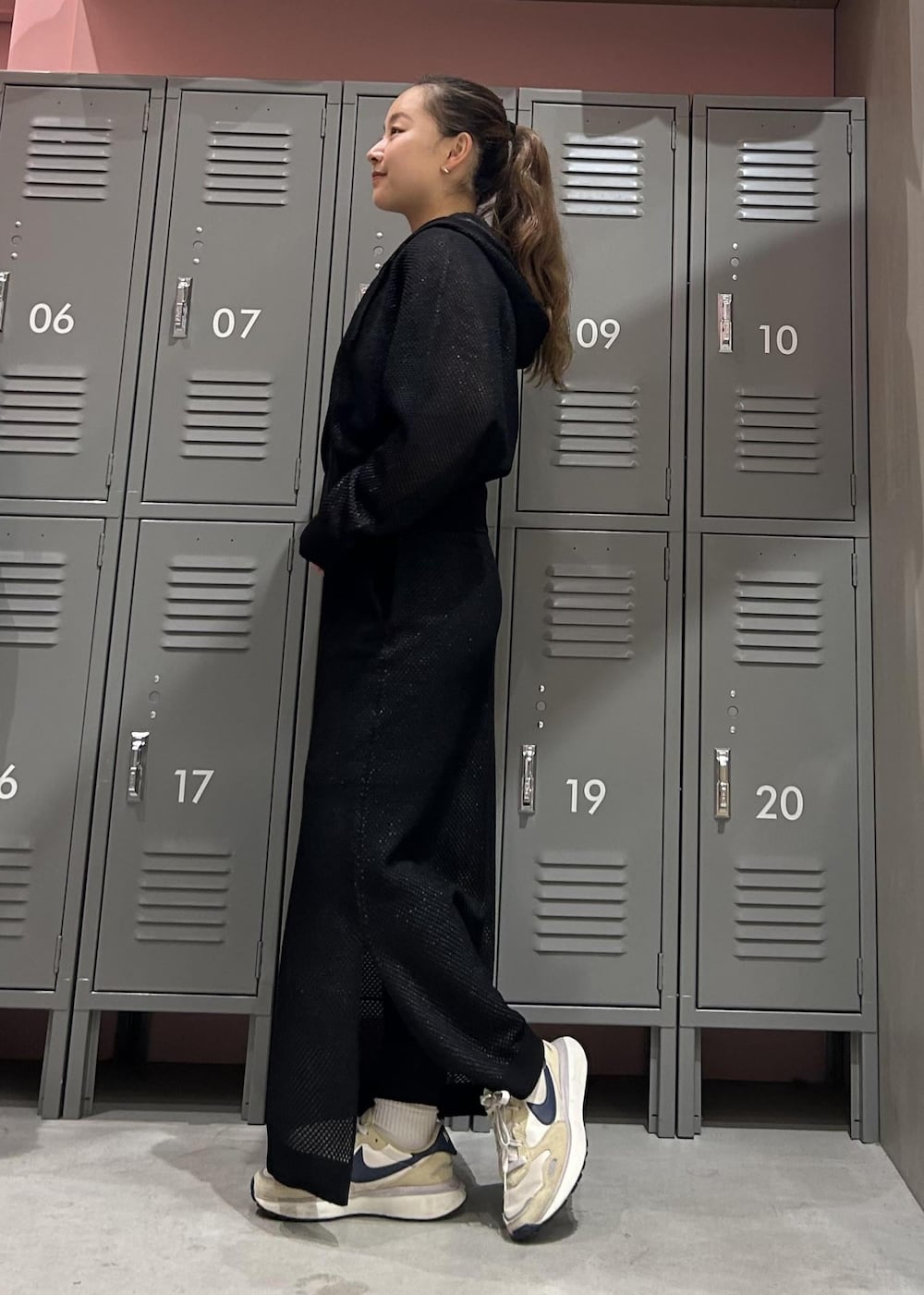 ベージュ系のスニーカー、ブラック系のパーカー、ブラック系のスカートを着用したレディースの冬コーディネートの2枚目の写真