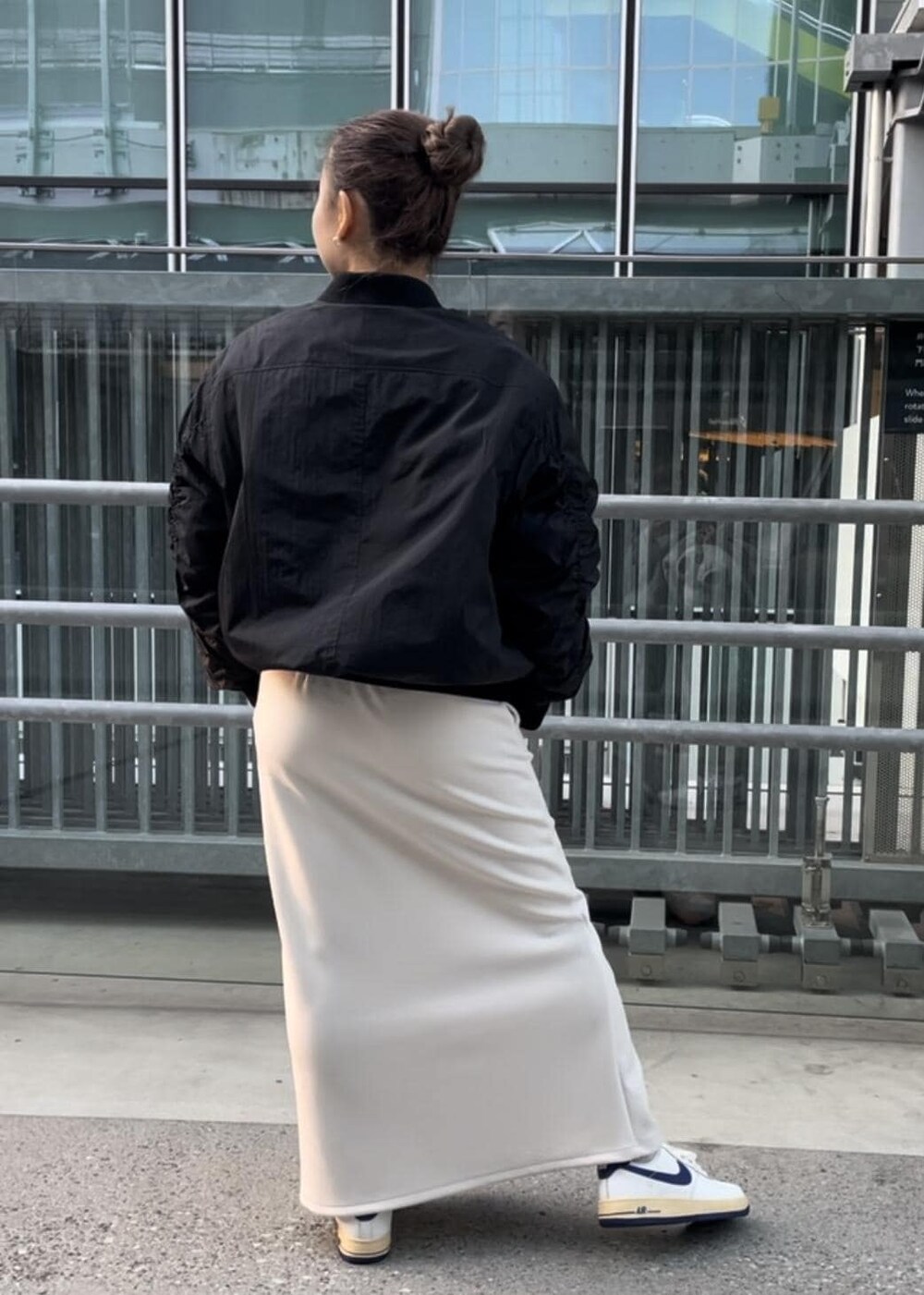 ホワイト系のスニーカー、ホワイト系のスカート、ブラック系のブルゾンを着用したレディースの冬コーディネートの3枚目の写真