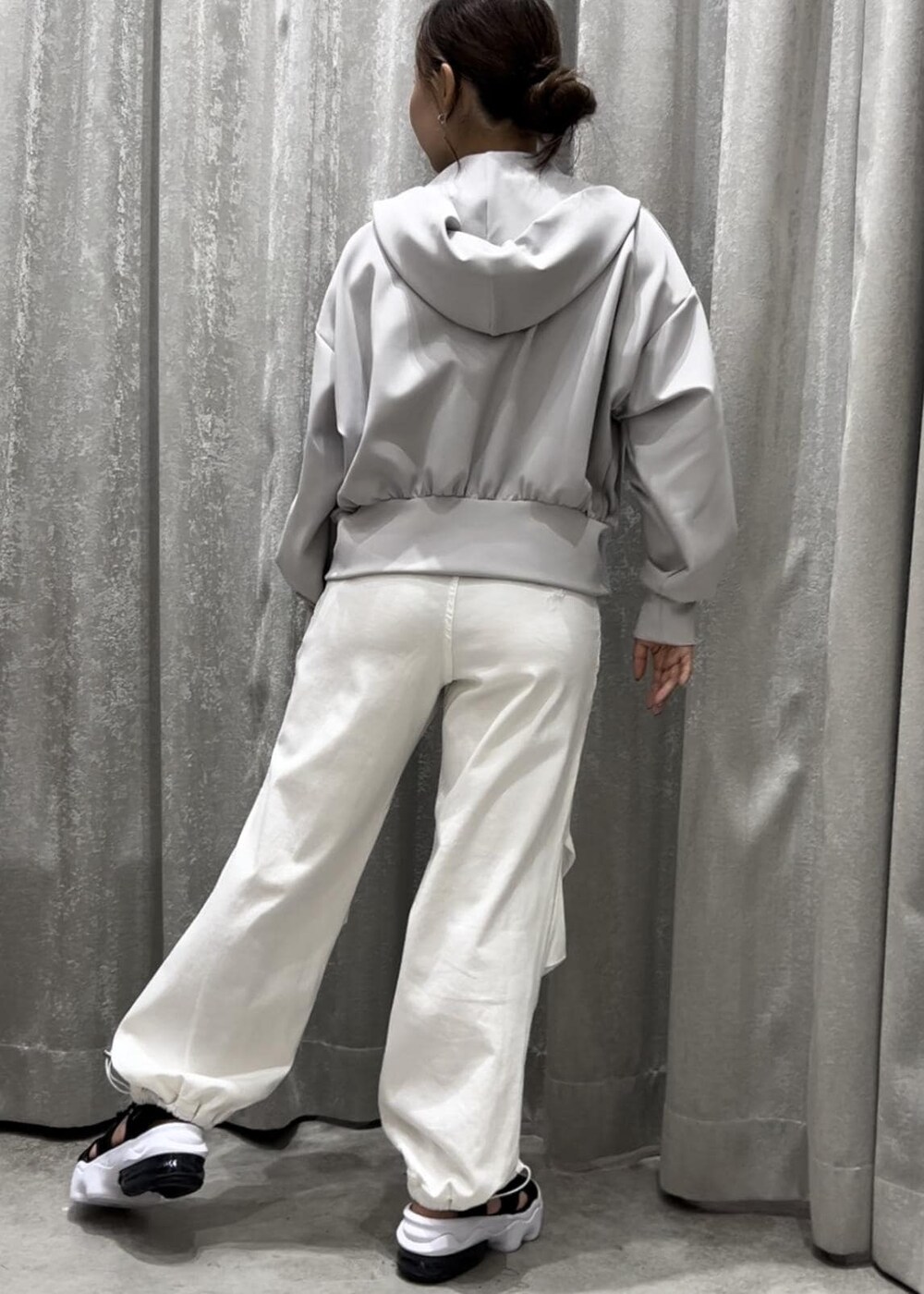 グレー系のパーカー、ホワイト系のその他パンツ、ブラック系のサンダルを着用したレディースの春コーディネートの3枚目の写真