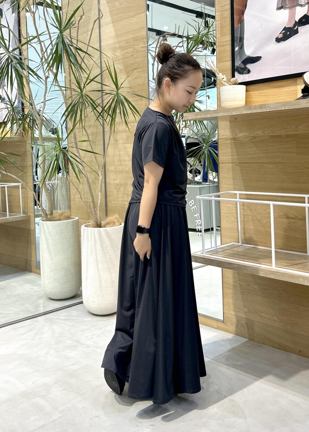 ブラック系のスニーカー、ブラック系のTシャツ/カットソー、ブラック系のスカートを着用したレディースの春コーディネートの2枚目の写真