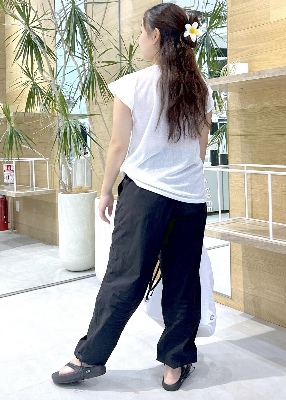 ブラック系のその他パンツ、ブラック系のサンダル、ホワイト系のバックパック/リュックを着用したレディースの秋コーディネートの3枚目の写真