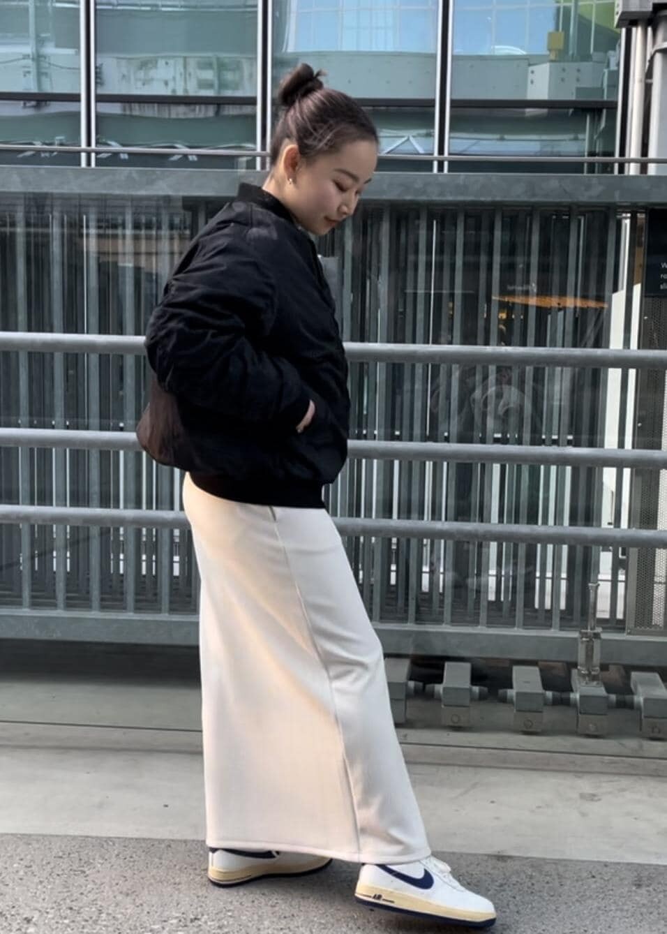 ホワイト系のスニーカー、ホワイト系のスカート、ブラック系のブルゾンを着用したレディースの冬コーディネートの4枚目の写真