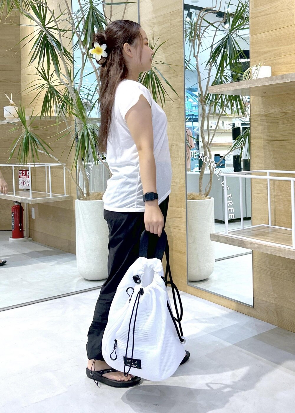 ブラック系のその他パンツ、ブラック系のサンダル、ホワイト系のバックパック/リュックを着用したレディースの秋コーディネートの2枚目の写真