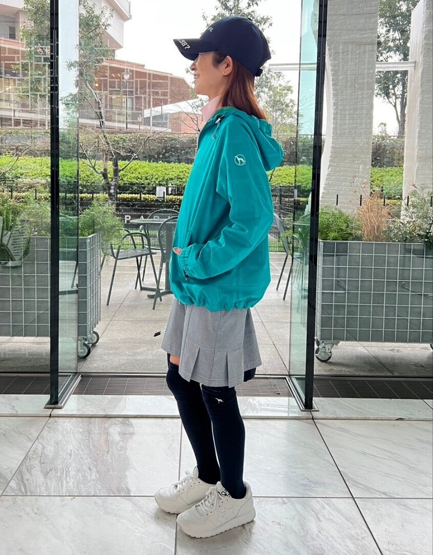 グリーン系のブルゾン、ブルー系のスカート、ブルー系のトートバッグを着用したレディースの春コーディネートの2枚目の写真