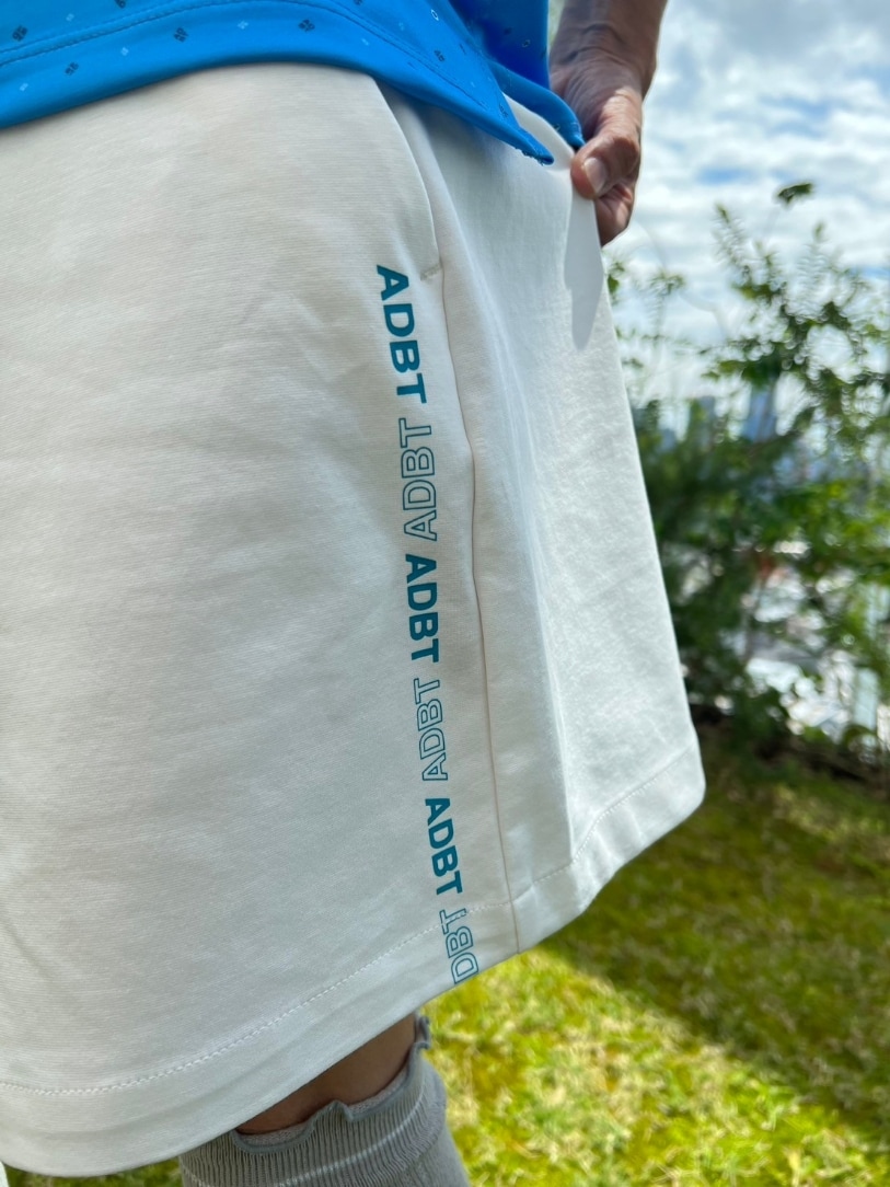 ブルー系のポロシャツ、ホワイト系のその他パンツ、ホワイト系のサンバイザーを着用したレディースの春コーディネートの6枚目の写真