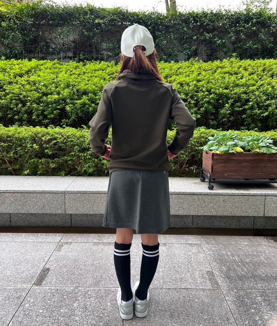 ブルー系のスカート、ホワイト系のキャップを着用したレディースの秋コーディネートの4枚目の写真