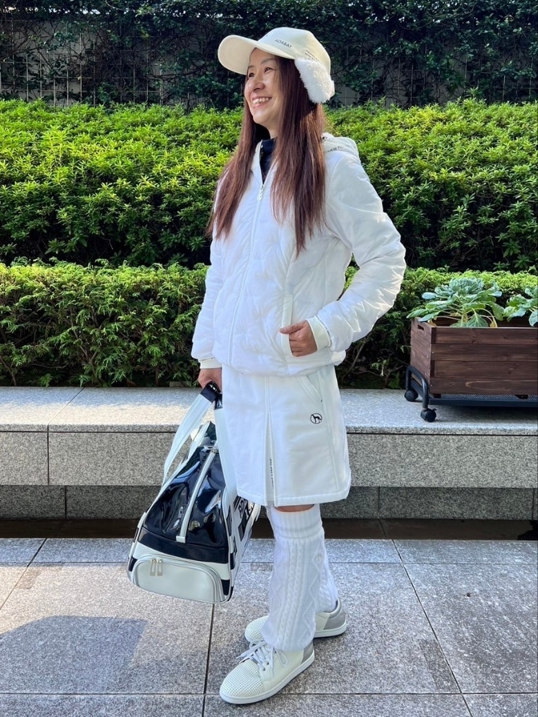 ホワイト系のダウンジャケット/コート、ホワイト系のスカート、ホワイト系のレッグウォーマーを着用したレディースの秋コーディネートの2枚目の写真