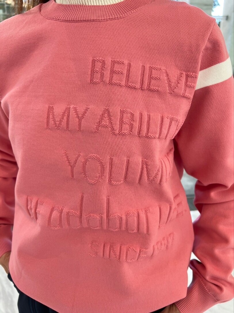 ピンク系のニット/セーター、ブルー系のスカート、ホワイト系のトートバッグを着用したレディースの冬コーディネートの4枚目の写真