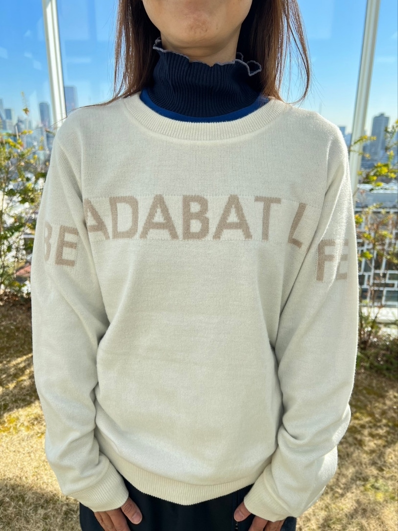 ホワイト系のニット/セーター、ブルー系のスカート、ブルー系のゴルフグッズを着用したレディースの冬コーディネートの4枚目の写真