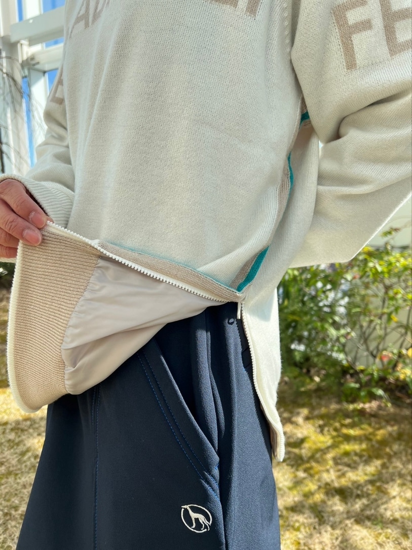 ホワイト系のニット/セーター、ブルー系のスカート、ブルー系のゴルフグッズを着用したレディースの冬コーディネートの6枚目の写真