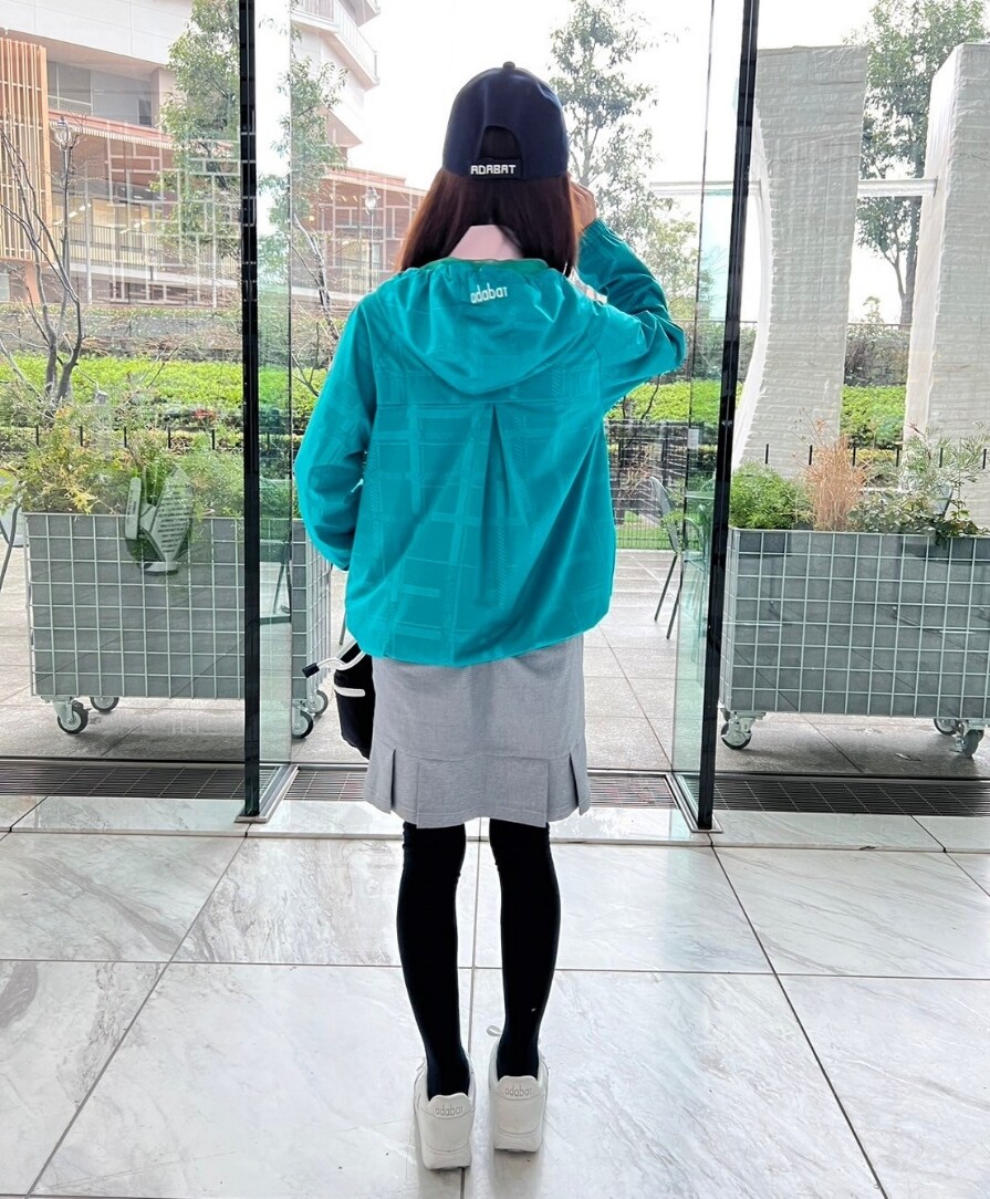 グリーン系のブルゾン、ブルー系のスカート、ブルー系のトートバッグを着用したレディースの春コーディネートの3枚目の写真