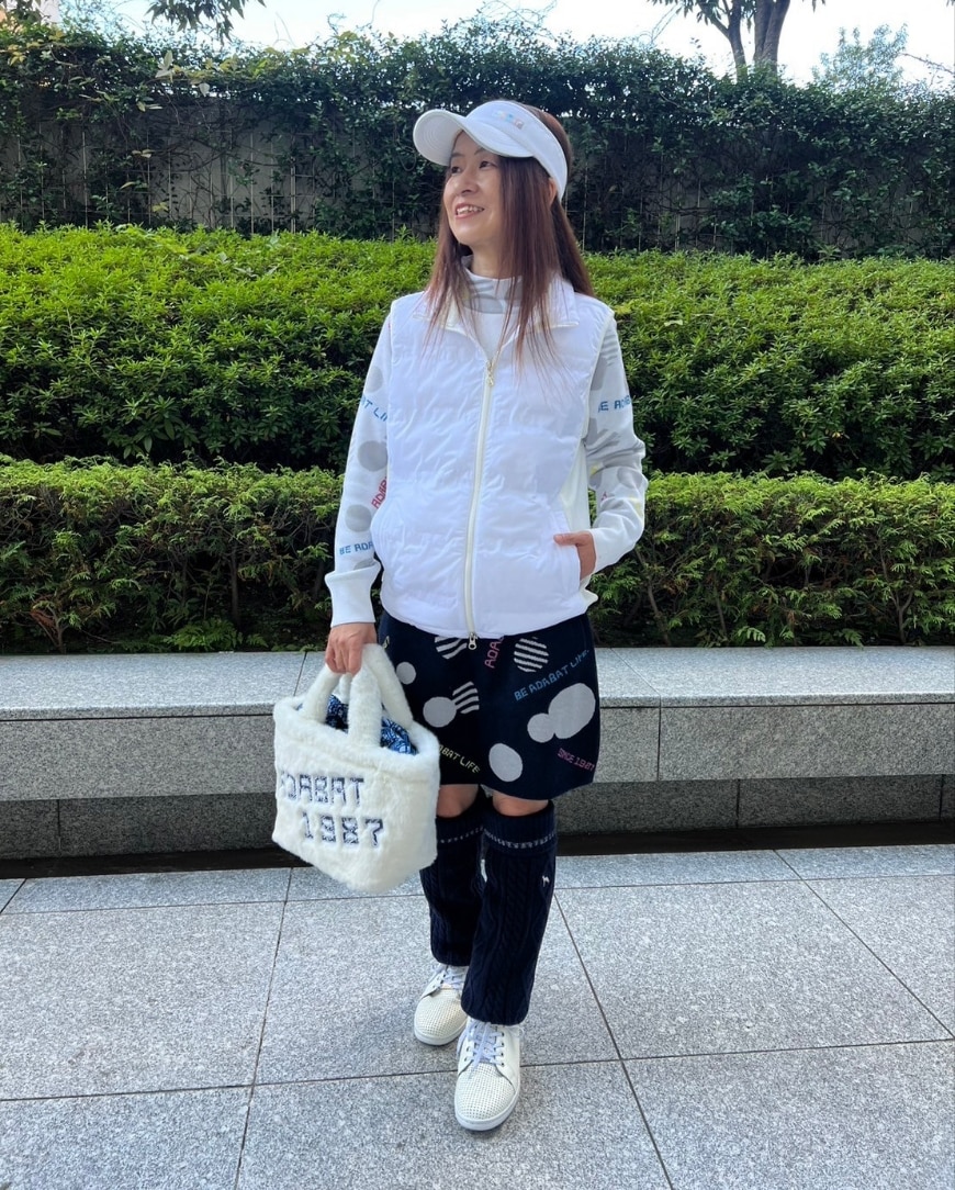 ホワイト系のその他アウター、ホワイト系のニット/セーター、ブルー系のスカートを着用したレディースの秋コーディネートの3枚目の写真